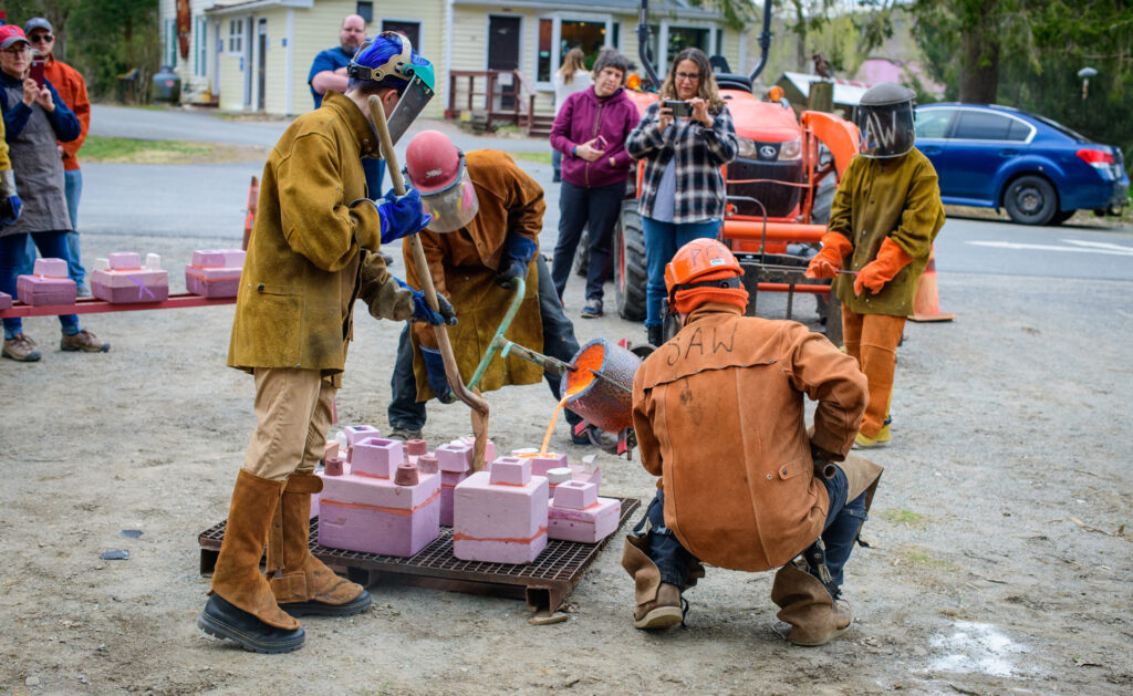 Students pouring molten iron into molds